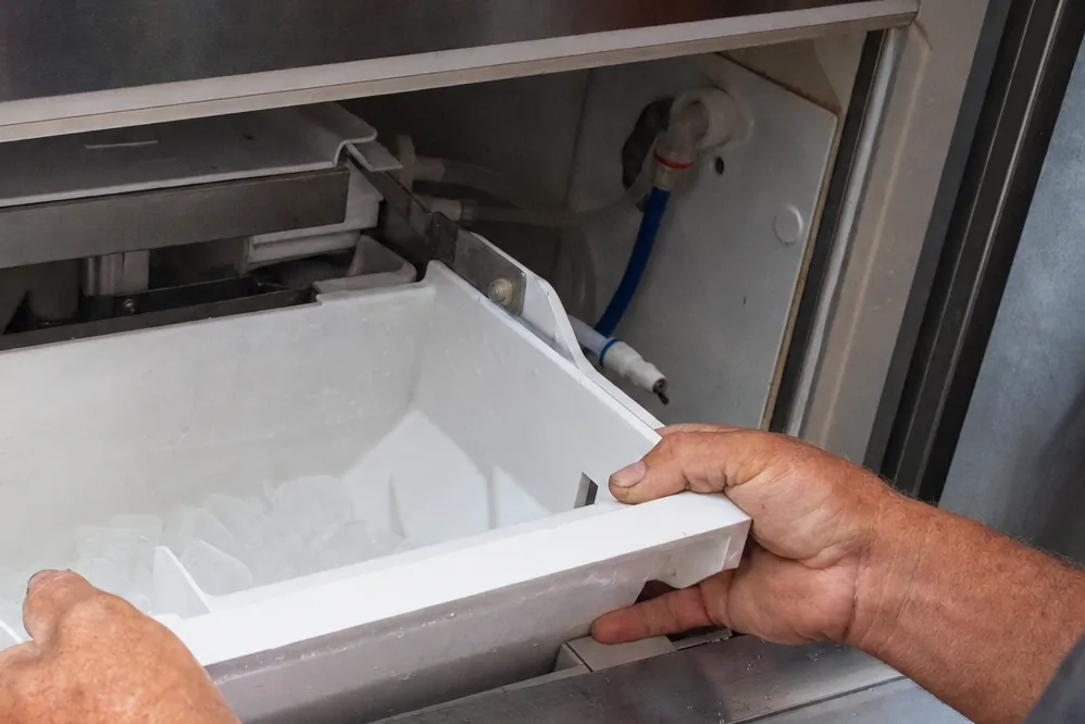 A close, plain view of the bin and mould of an ice machine with the cabinet open